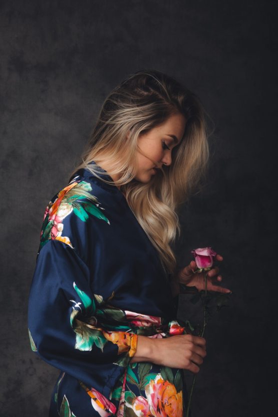 Vrouw in satijnen kimono met roos in haar hand