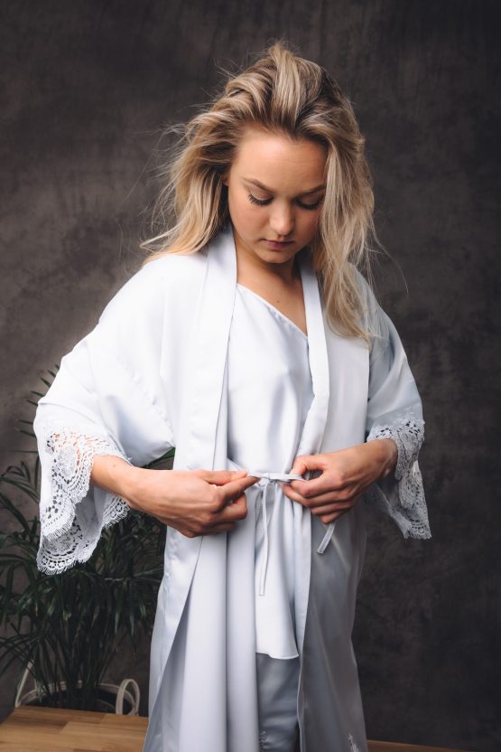 Vrouw is haar satijnen kimono aan het dicht strikken aan de binnenkant