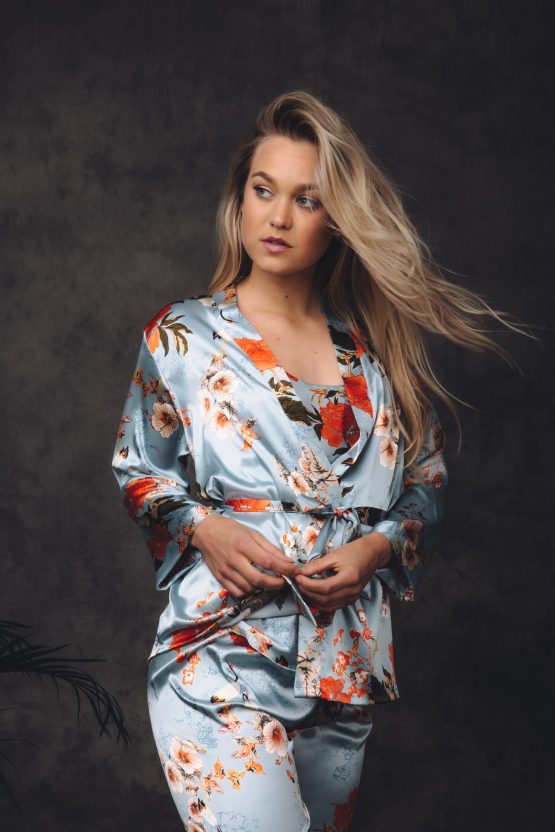 Vrouw in satijnen pyjama met bloemenprint