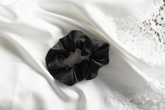 satijnen scrunchie zwart liggend op witte kimono satijn
