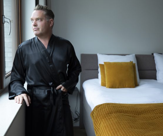 man in kimono satijn zwart in slaapkamer