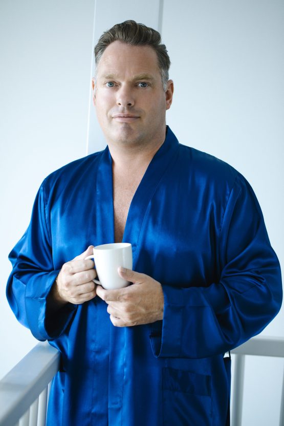 Man in blauwe satijnen kimono met kop koffie