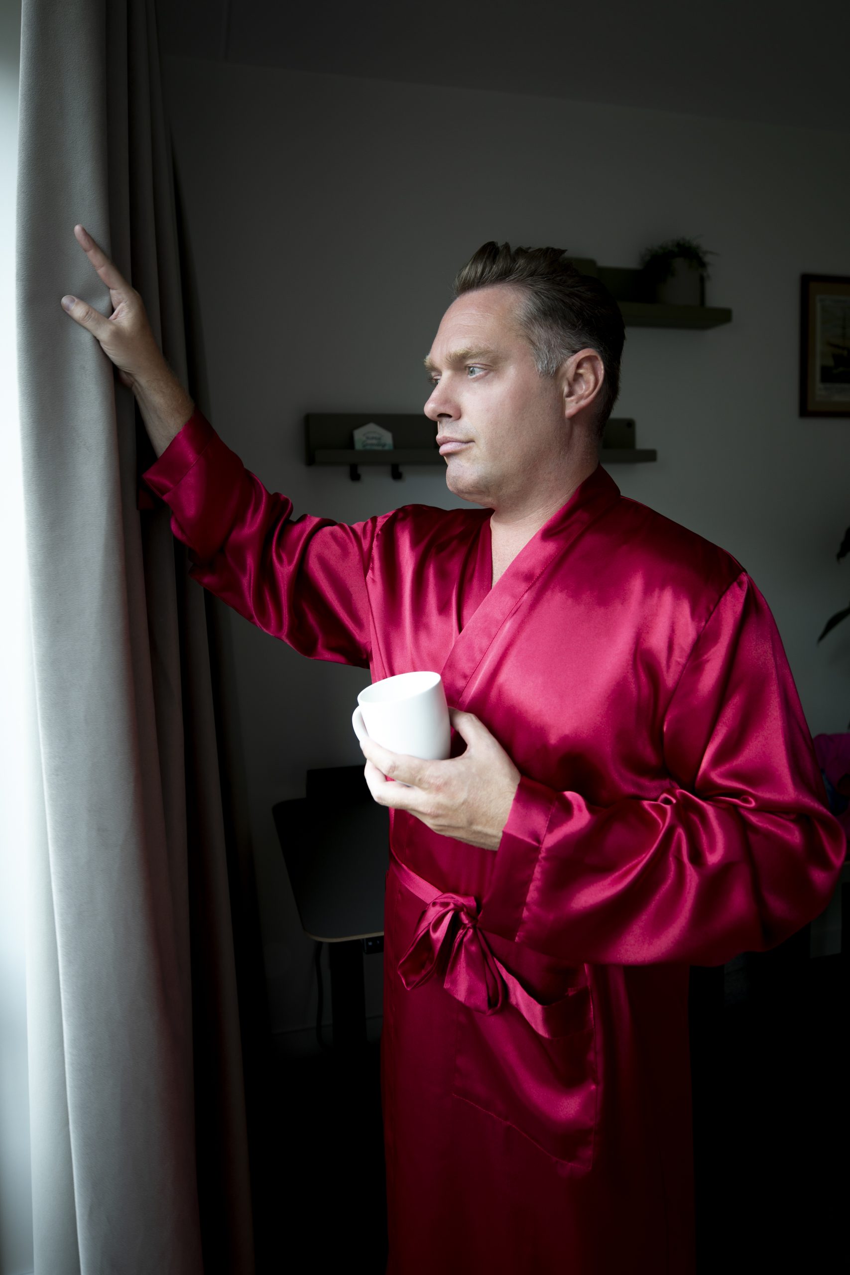 man in satijnen kimono met kop koffie