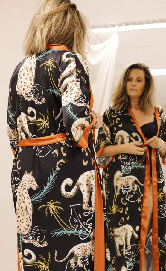 Vrouw in satijnen panter kimono voor spiegel
